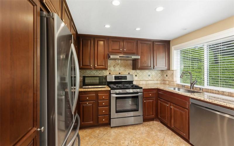 Updated kitchen with granite counters, custom cabinetry and stainless steel applancies