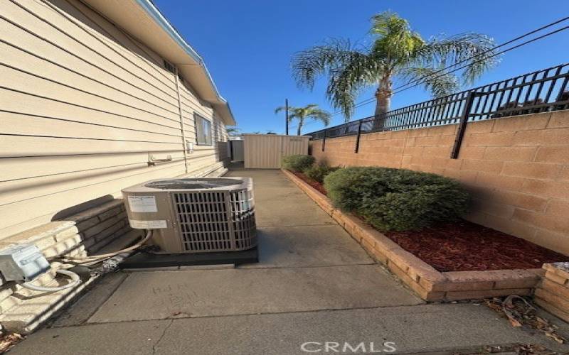 Back yard with new Air Conditioning condensing unit.