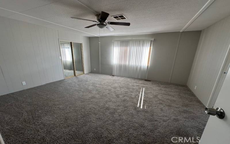 Master bedroom with new ceiling fan and mirrored wardrobe doors.