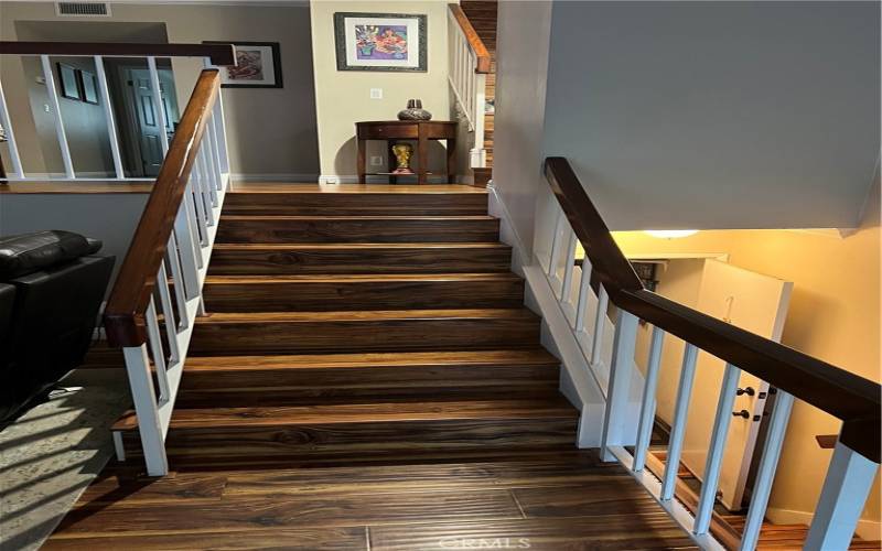 living room stairs leading to dining room and on right side stairs leading to garage.