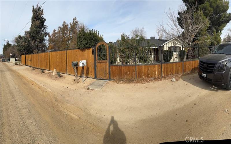 This beautiful wooden fence surrounds the property, adding to its curb appeal. The fence is well-maintained and complements the home's exterior.