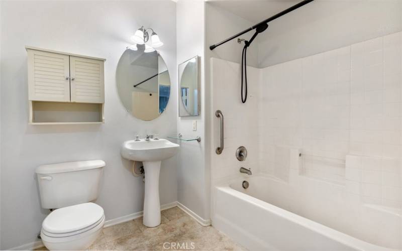 A spacious restroom with a tub that allows you to soak in after a long day.