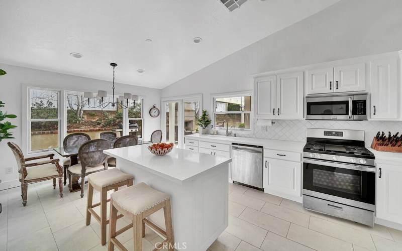 Kitchen with island and 5 burner stove with vented hood