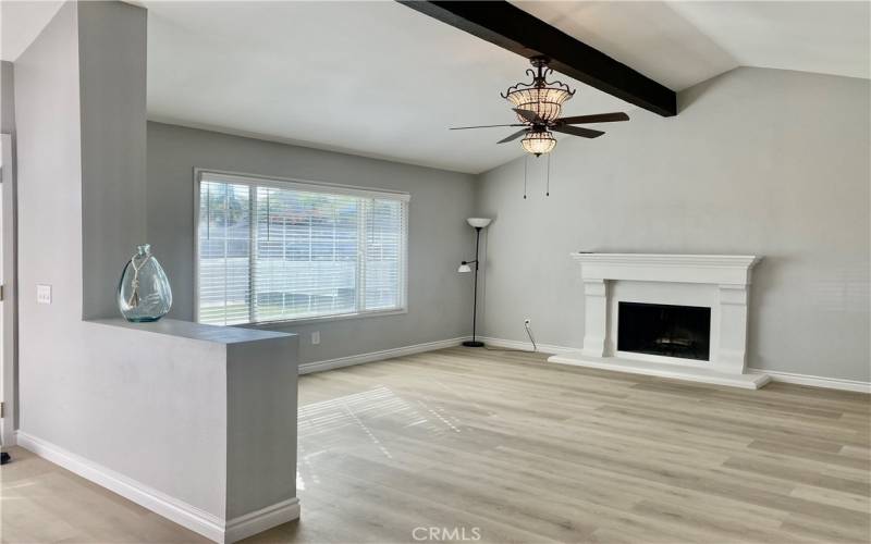 Spacious living room with beautiful fireplace and large window to let the light in.