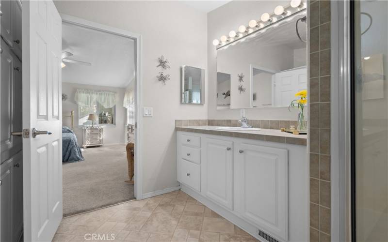 Primary suite bathroom with a wall of linen cabinets behind the door.
