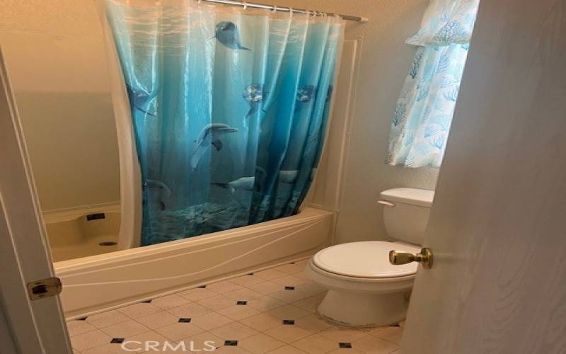 Guest Bathroom on the opposite end of the home serving 2 Guest Bedrooms. Shower Over tub, Single Vanity and easy to maintain Vinyl Flooring