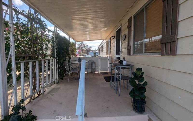 Large Covered Front Porch is divided with sitting area in front and gate to fully fenced back yard