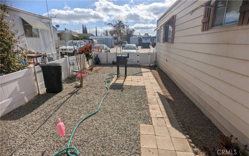 Vies of back yard from porch. Home backs to the gated RV parking area of park