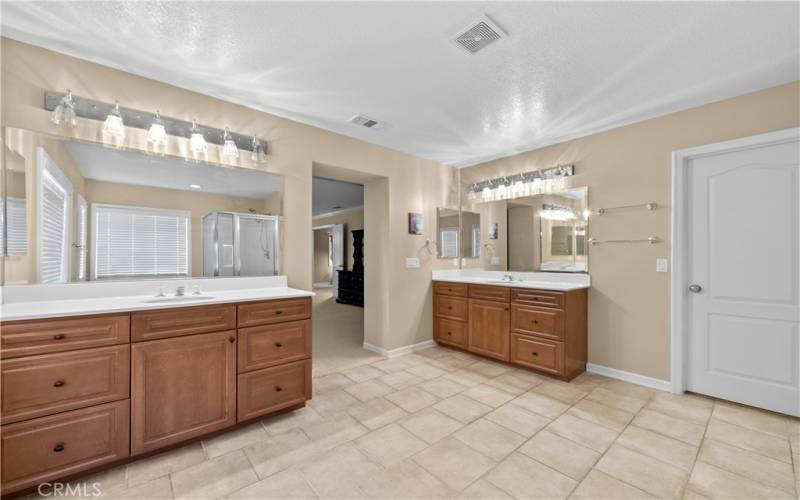 Primary bathroom with separate vanities.