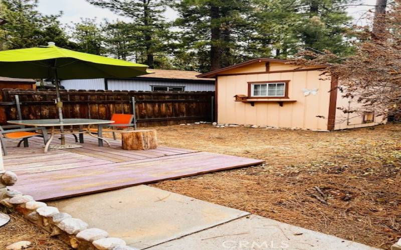 In addition to the shed, the back outdoor area also has a deck with patio table, chairs, and umbrella, ready for you to enjoy the majestic and tranquil scenery and fresh mountain air.