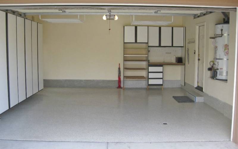 Garage with built in cabinets and desk, upgraded enamel floors.