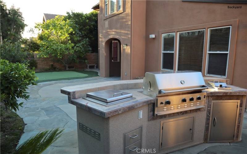 Backyard with private bbq, mini golf greens, fruit trees, and outdoor speaker.