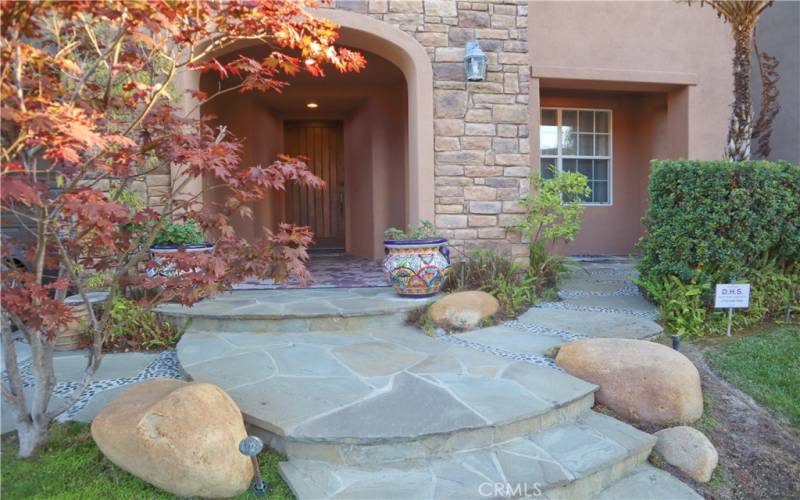 Entrance, patio, and professional landscaping