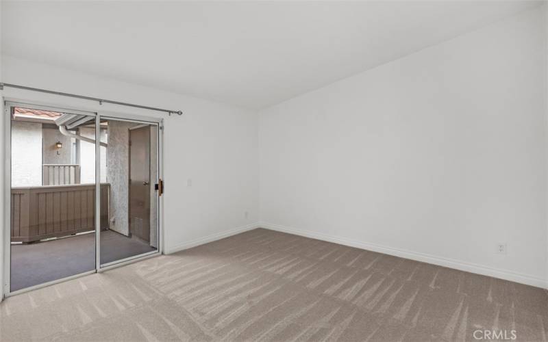 Primary bedroom with slider to deck and laundry area