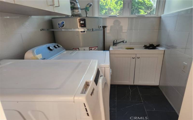 Conveniently located upstairs laundry room has a utility sink and brand new dryer