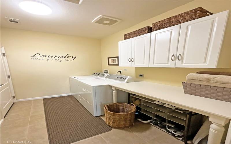 Laundry room with cabinetry and folding area.