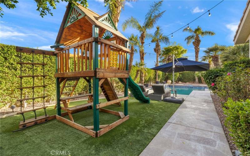 Children's playset in the backyard is included.