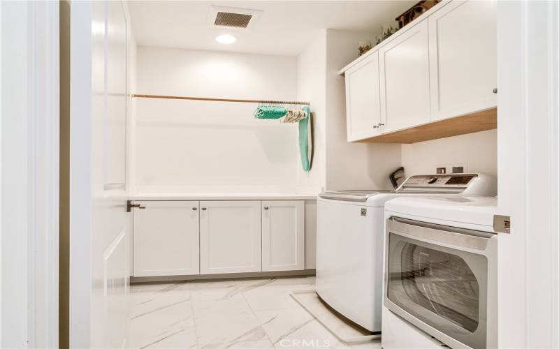 Separate laundry room complete with plenty of storage & drying area