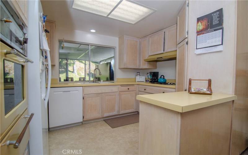 kitchen and window opening to sunroom / enclosed patio / TV room office room