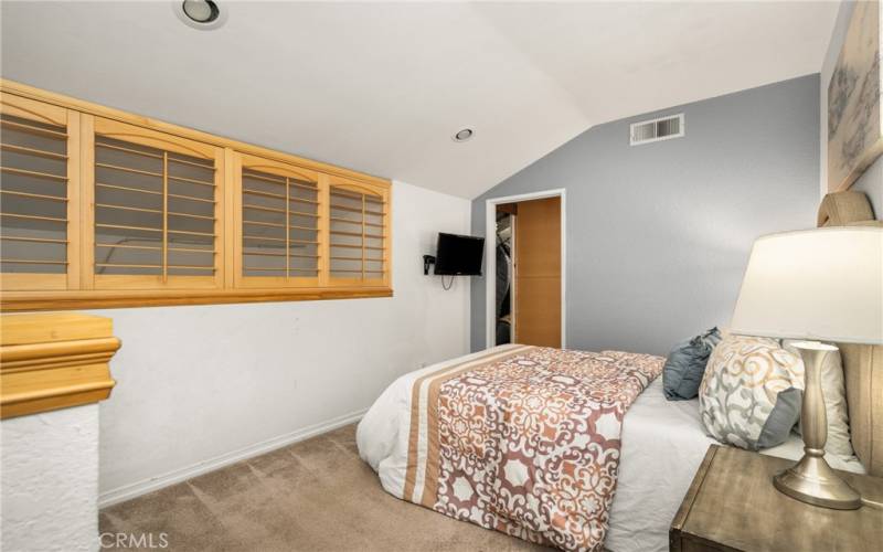 The upstairs bedroom features shutters that can be opened or closed for privacy.