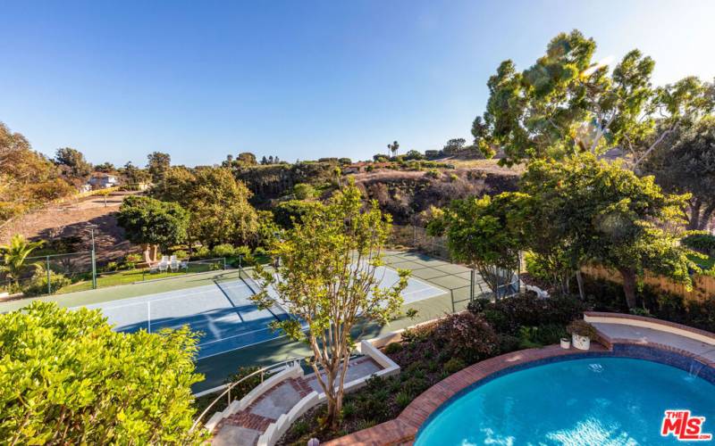 Pool overlooking tennis court.