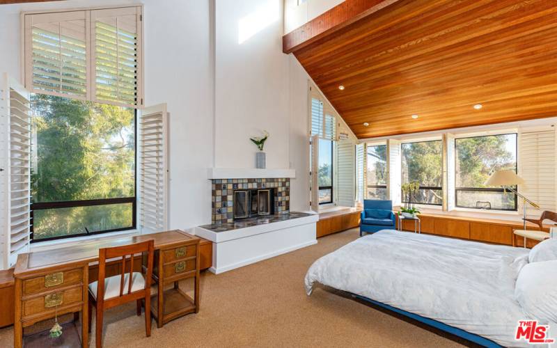 Master bedroom with vaulted ceilings and fireplace.