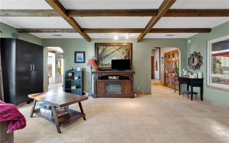 Formal living room has windows on opposing sides, overlooking a private courtyard patio with outdoor kitchen, and the tremendous view across the skyline.