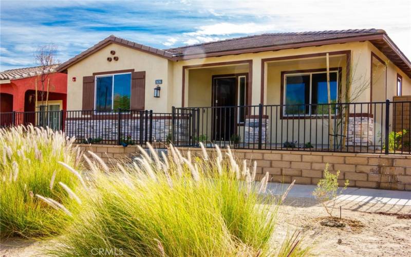 Front of home with Iron gates and covered patio.