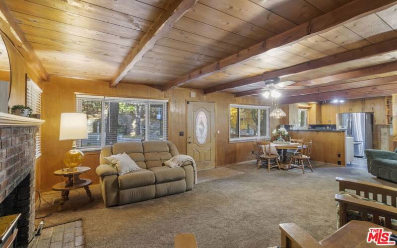 Open beam ceilings next to cozy fireplace.