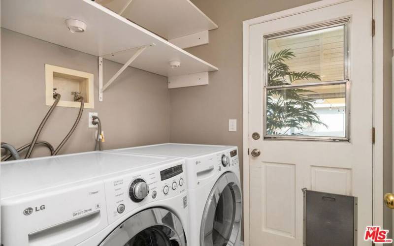 Laundry Room with LG Steam Washer/Dryer and separate entrance with storage cabinets and shelving