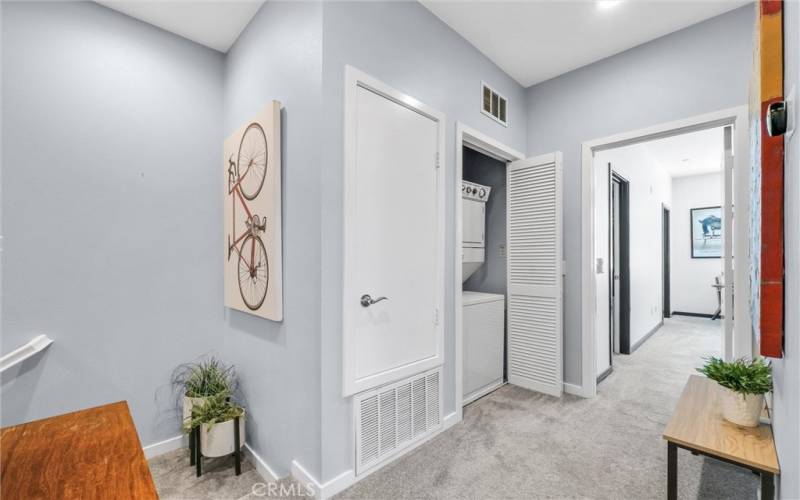 Upstairs hallway with stackable washer/dryer area on left and 2nd bedroom straight ahead.