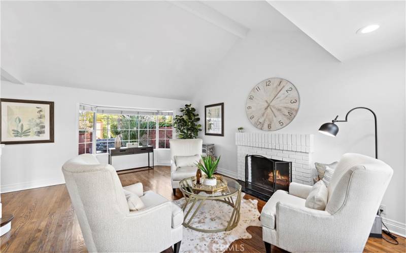 Formal Living room with gas fireplace, high ceilings, and lots of windows.