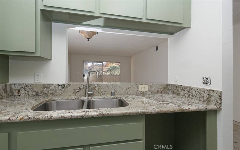 Kitchen to living room with view of trees.