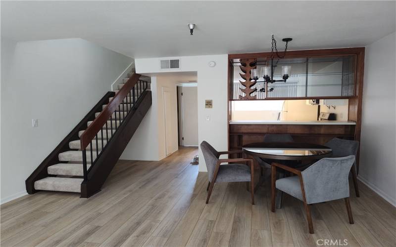 Living and dining room looking into kitchen and upstairs