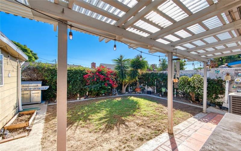 Private backyard, complete with plants, flower beds and plenty of space for BBQs or relaxation.