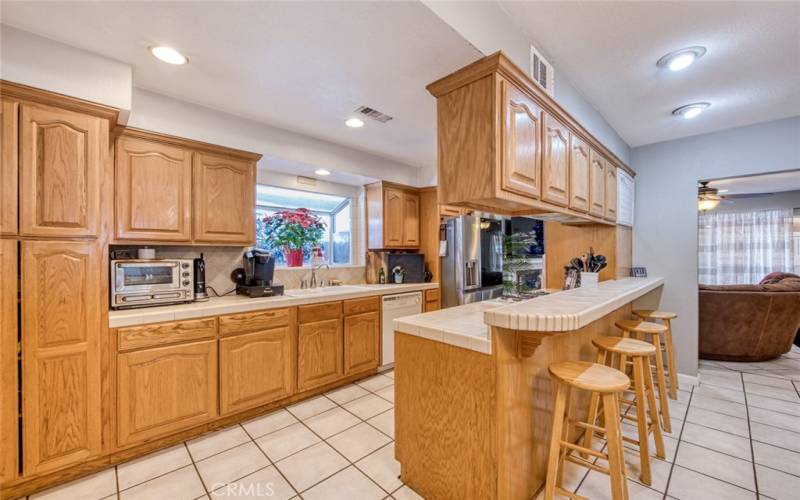 Kitchen boasts custom oak cabinetry with tile countertops.