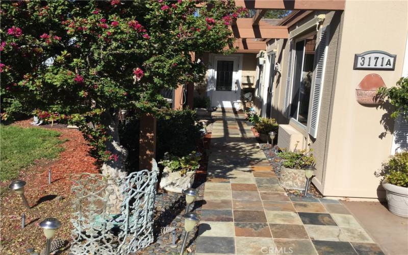 Entry to residence showning slate walkway, large side yard.