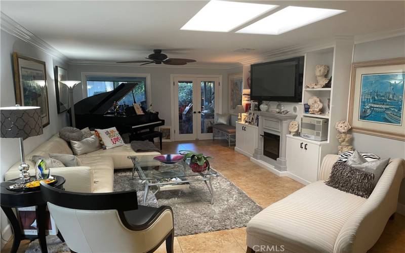 LIVING RM WITH BLT-IN TV, FP AND BOOKSHELVES. A BABY GRAND PIANO FOR ENTERTAINMENT