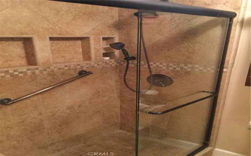 Porcelain tile shower with safety grab bar in guest bath