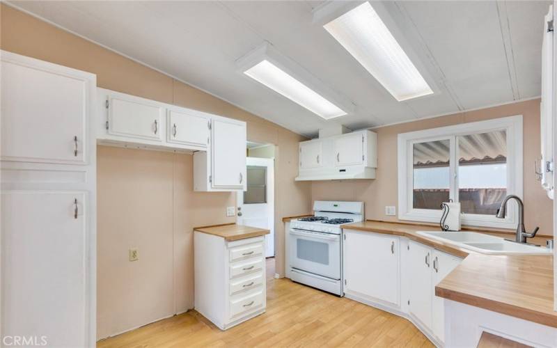 Kitchen View with Back Entry and Laundry Area beyond the Oven