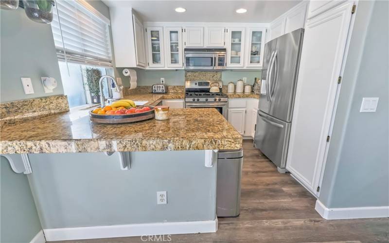 Kitchen has white cabinets and granite counters- includes refrigerator