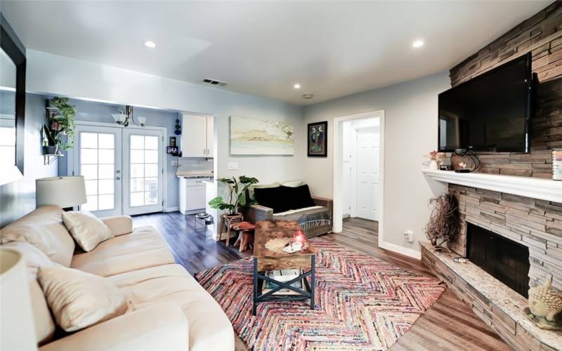 Living Room with French Doors  leading to back yard. Stacked stone fireplace.