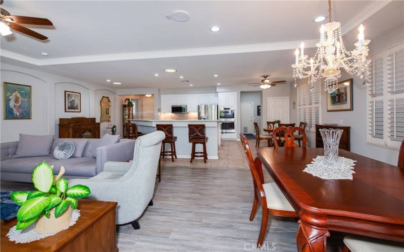 Dining room with coffered ceiling and lovely chandelier looking towards the kitchen.