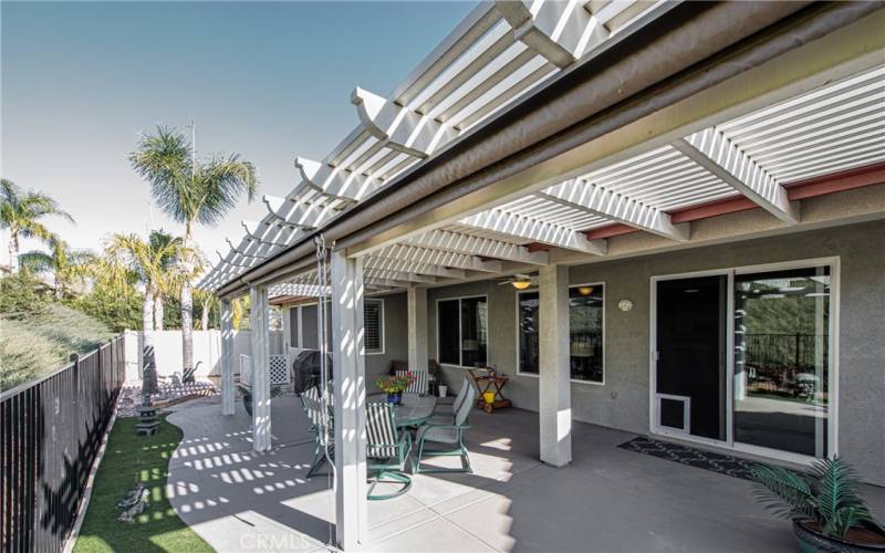 Full width covered patio, yard, palm trees, gardens, artificial turf, green belt views and ceiling fan.