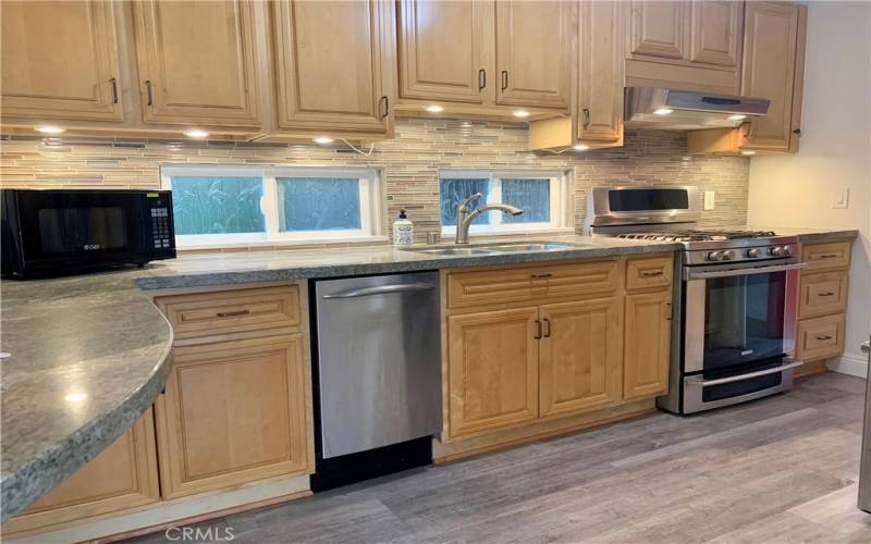 Kitchen w breakfast bar and gas stove.