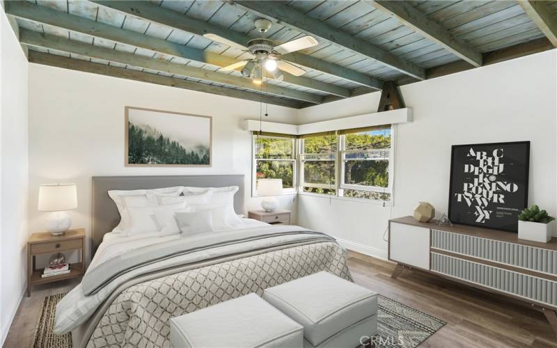 Primary bedroom, wood beam ceiling and ceiling fan.