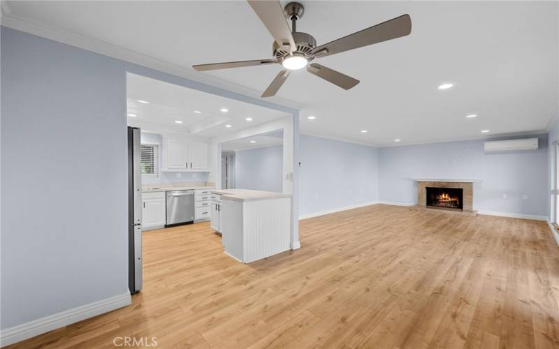 View of living room from dining area with wood burning fireplace