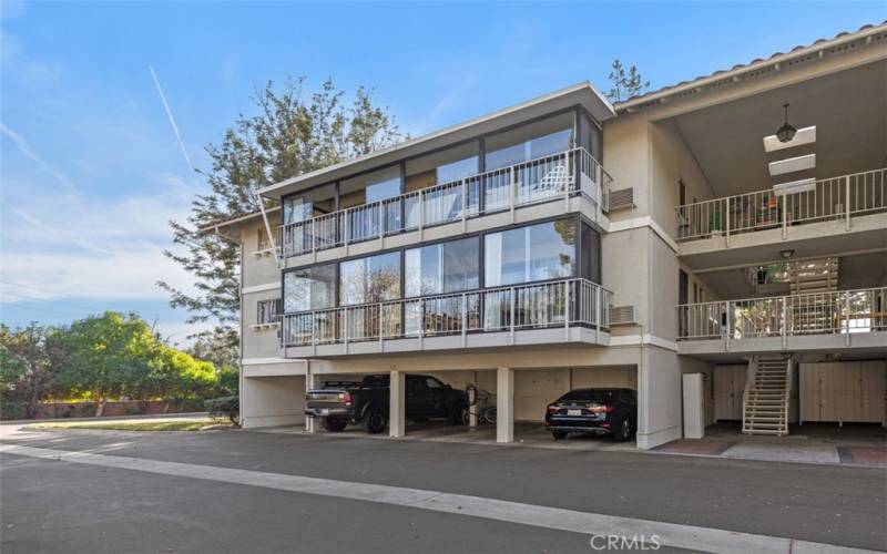 Looking up at glass enclosed balcony. Carports shown ARE NOT for the property.  No steps from the actual carports.  This a back entrance with stairs.