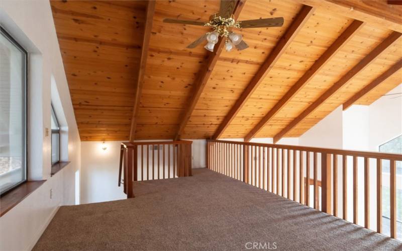 The loft has windows that overlook the backyard area.