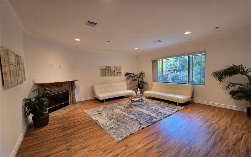 Living room has high ceiling, fireplace and views of trees